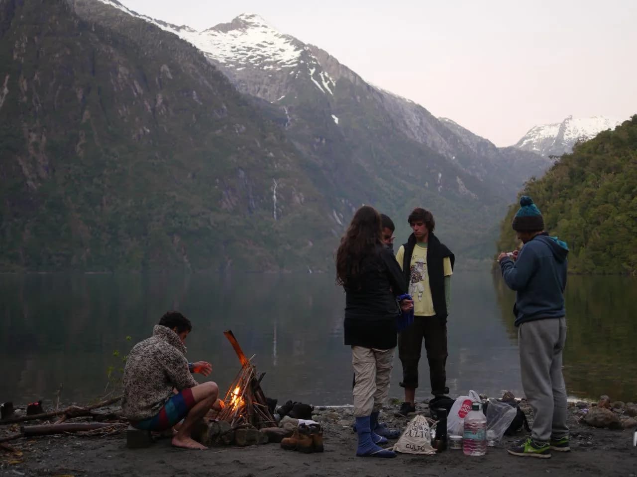 Charter privado Western Patagonia — grupo de amigos junto a una fogata en un fiordo