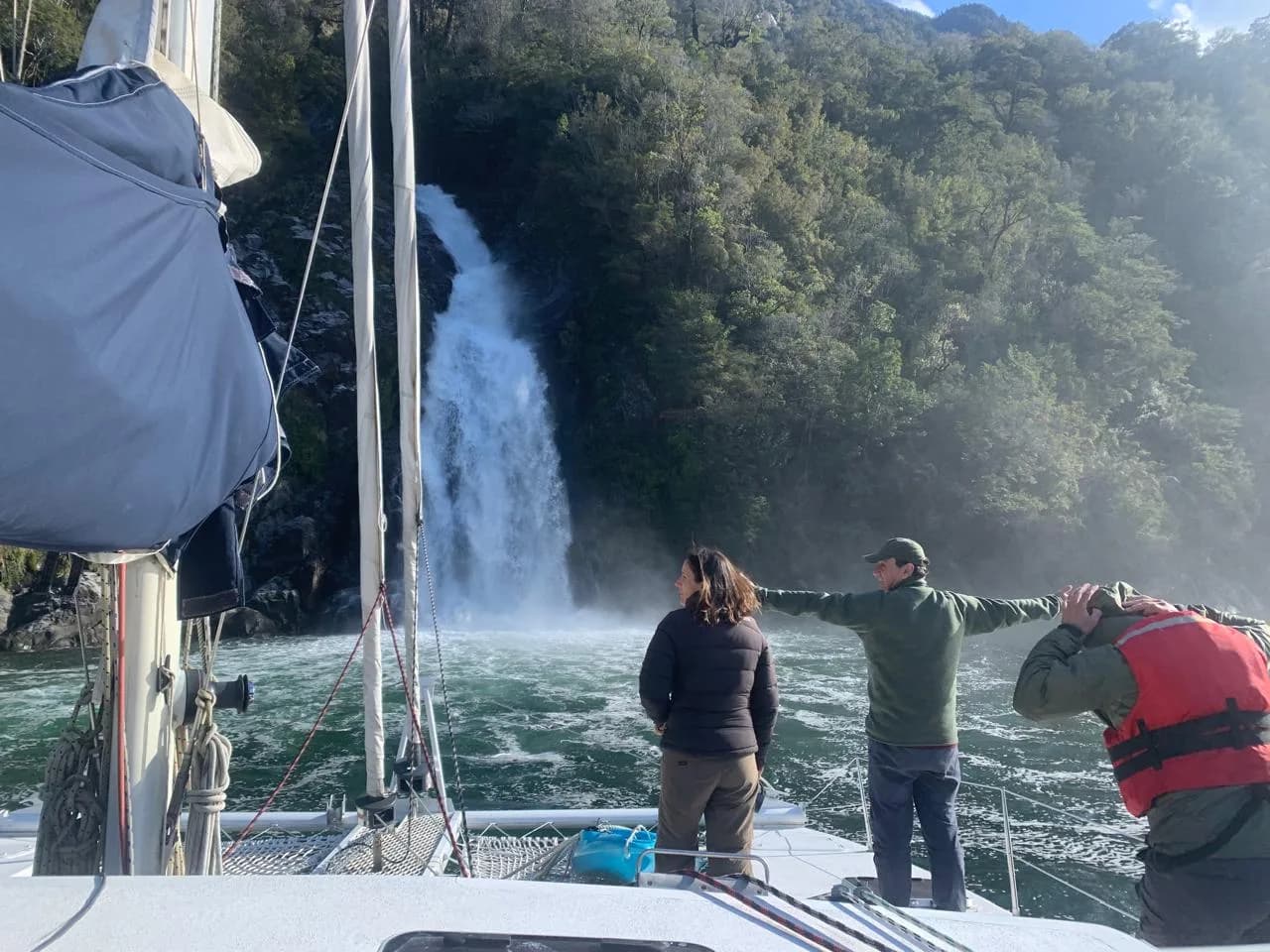 Charter privado Western Patagonia — grupo observando una cascada desde la proa