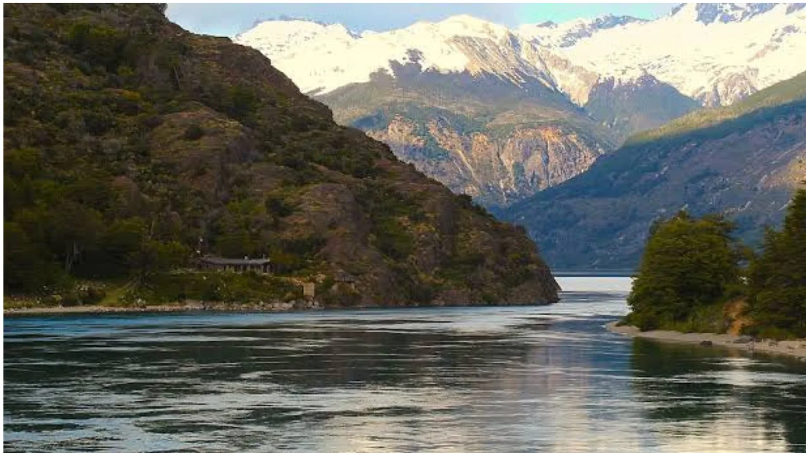 Fiordo patagónico con cumbres nevadas al fondo