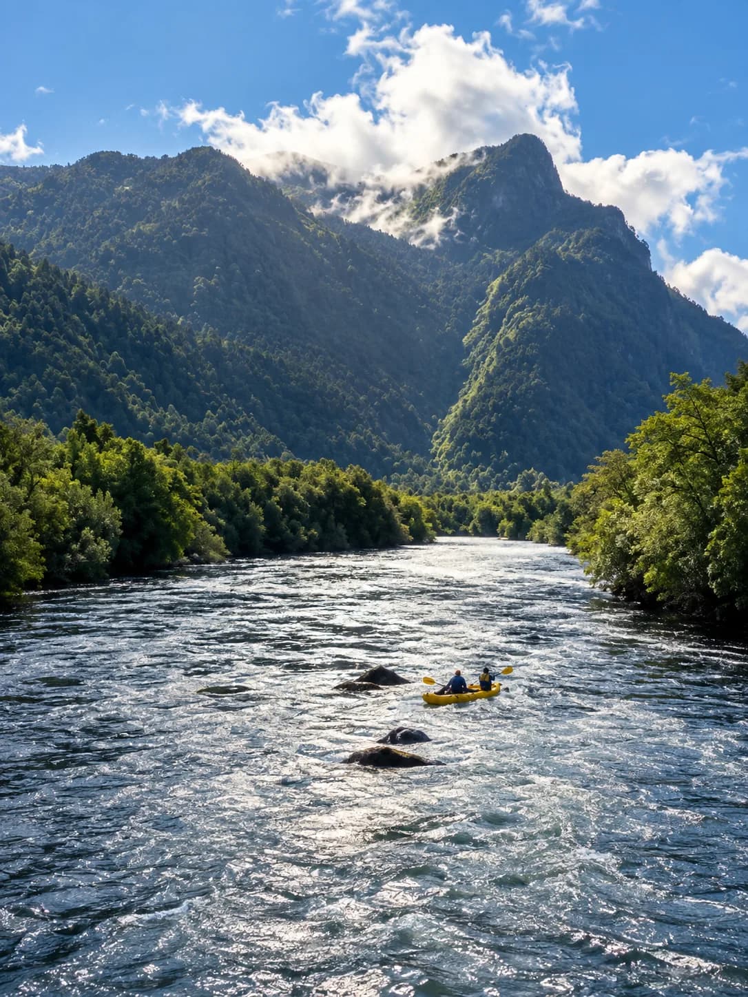 Kayak descendiendo un río entre montañas boscosas, Bahía Pumalín