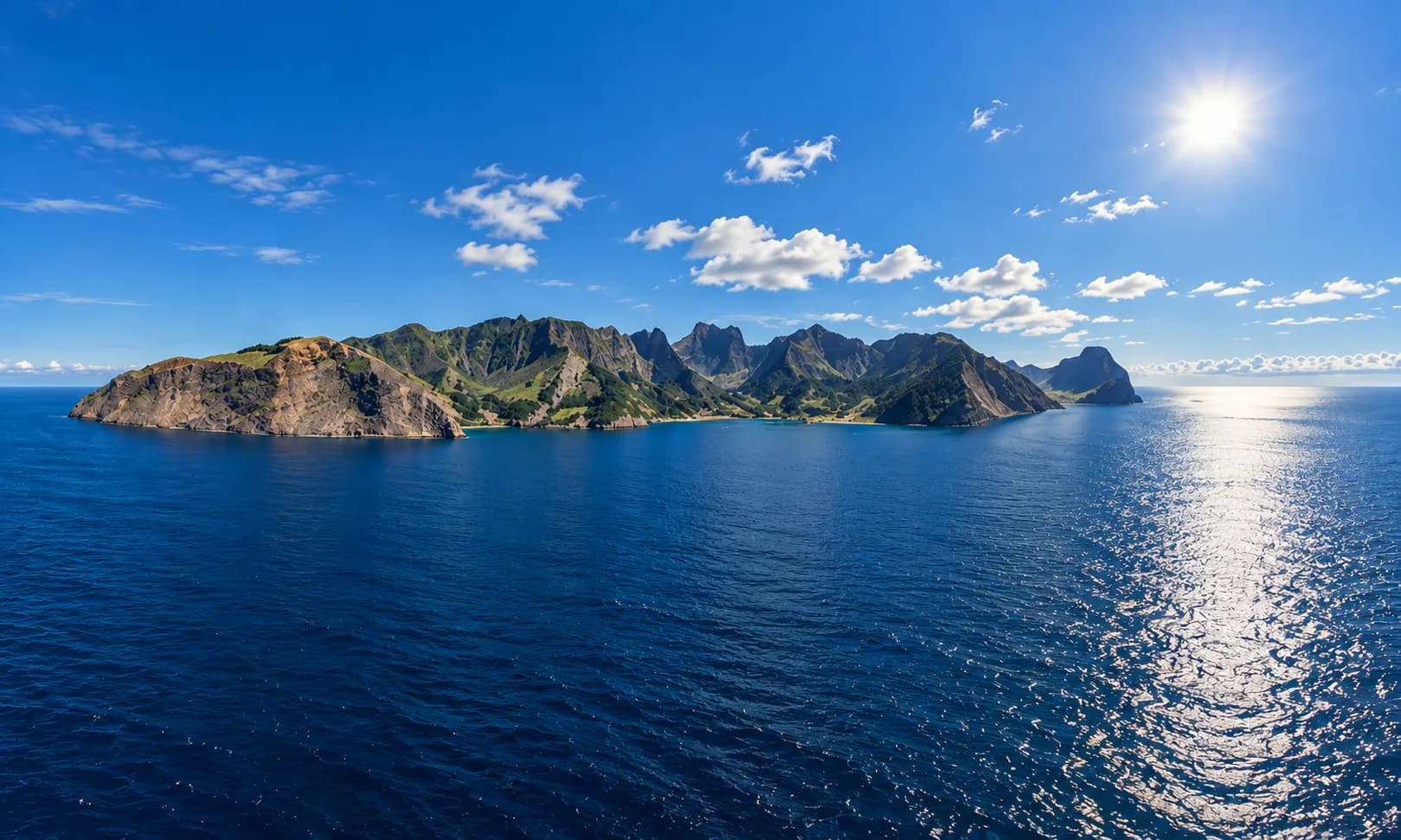 Vista panorámica de la Isla Robinson Crusoe desde el mar, con sus montañas volcánicas y acantilados